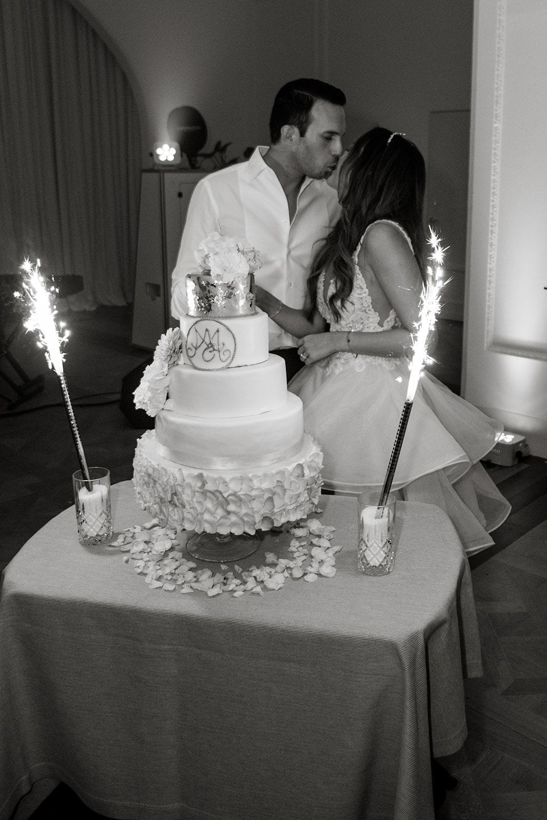 Bride and groom kiss before reception cake cutting