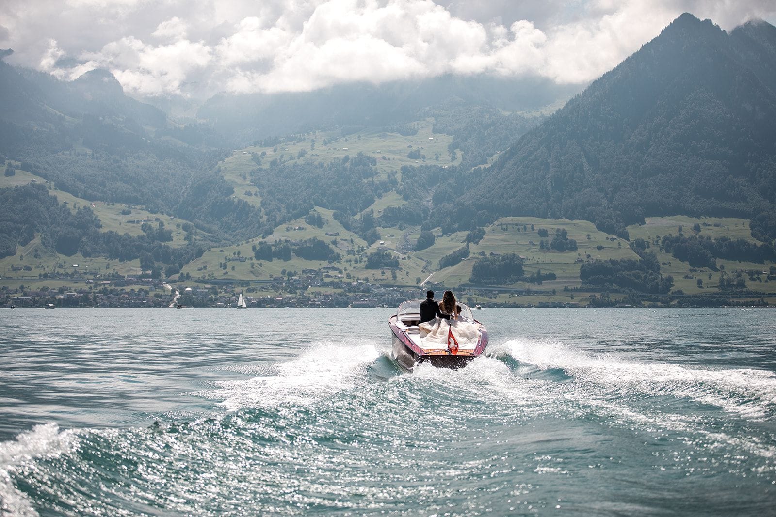 Bride and groom take boat ride for the scenic Lake Lucerne mountains