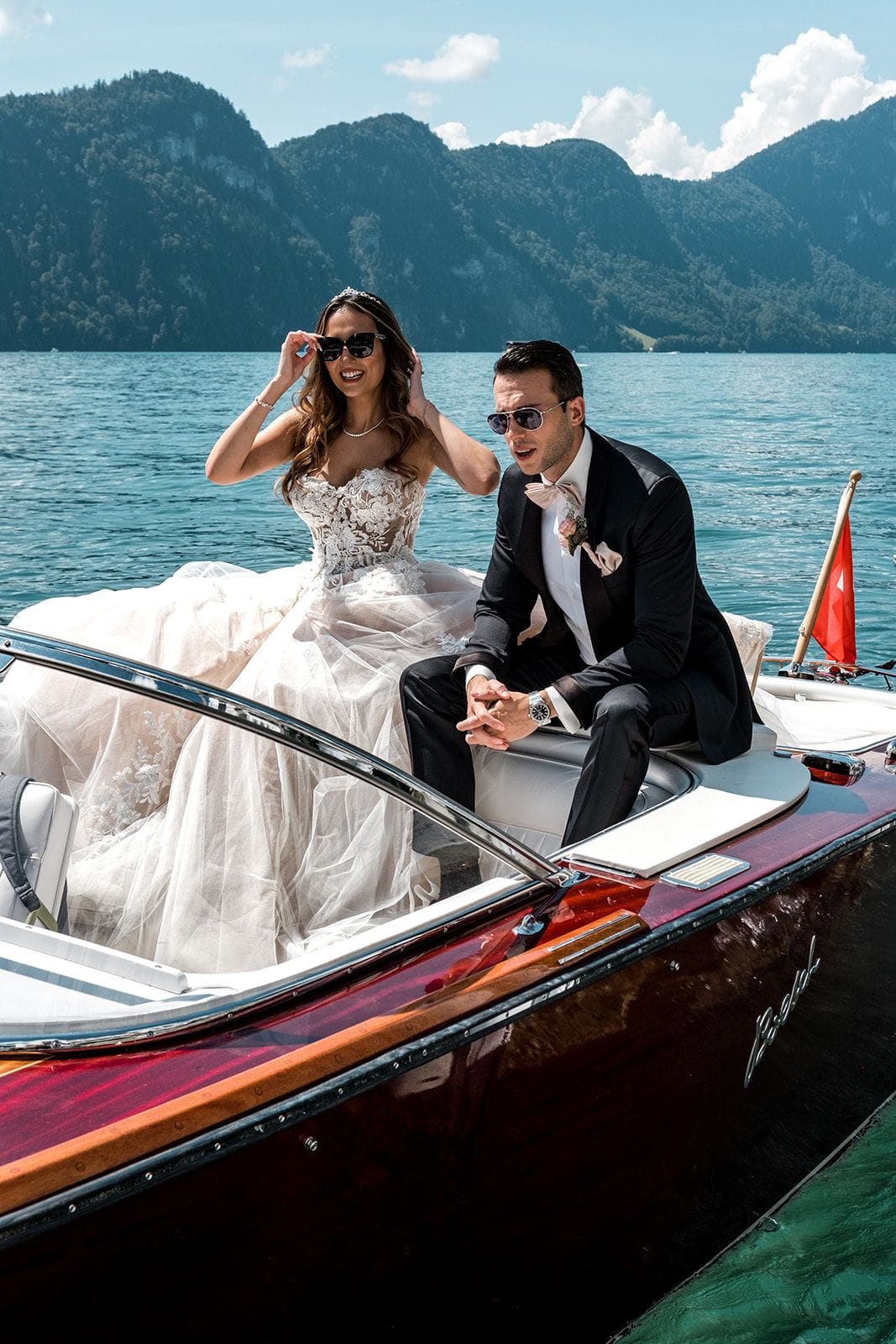 Bride and groom sit on boat before Lake Lucerne wedding ceremony