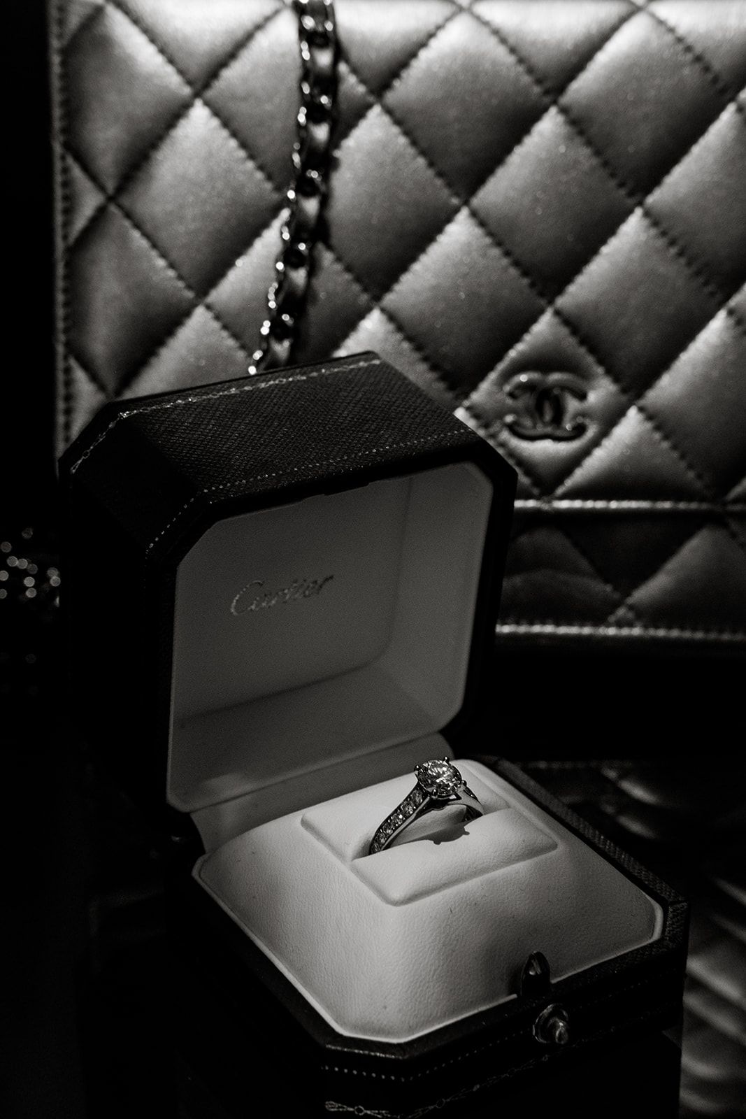 Black and white photo of a Cartier engagement ring in a ring box