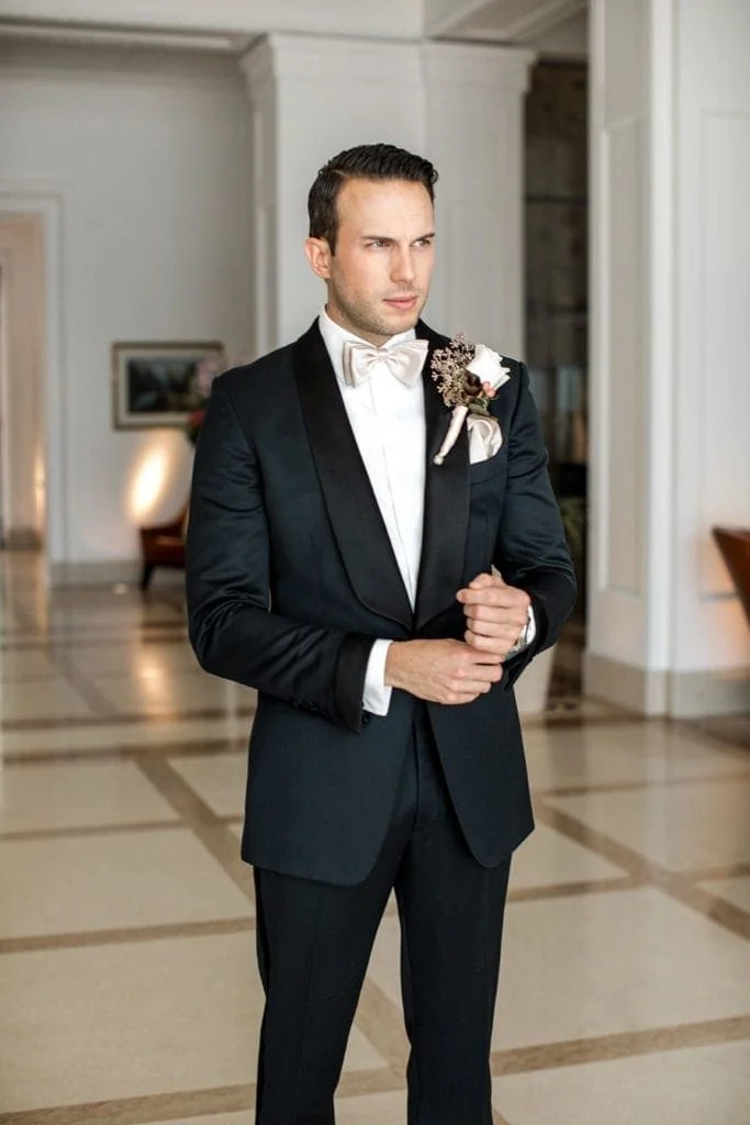Groom wears classic black groom's tuxedo as classic groom's wedding attire