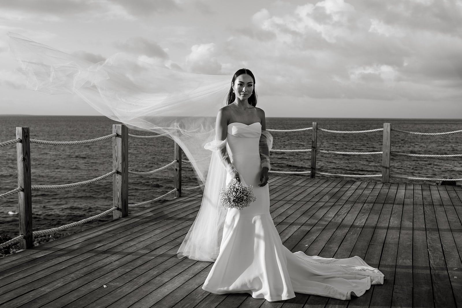 Bridal portrait with bride on dock in Anguilla while veil blows in the wind