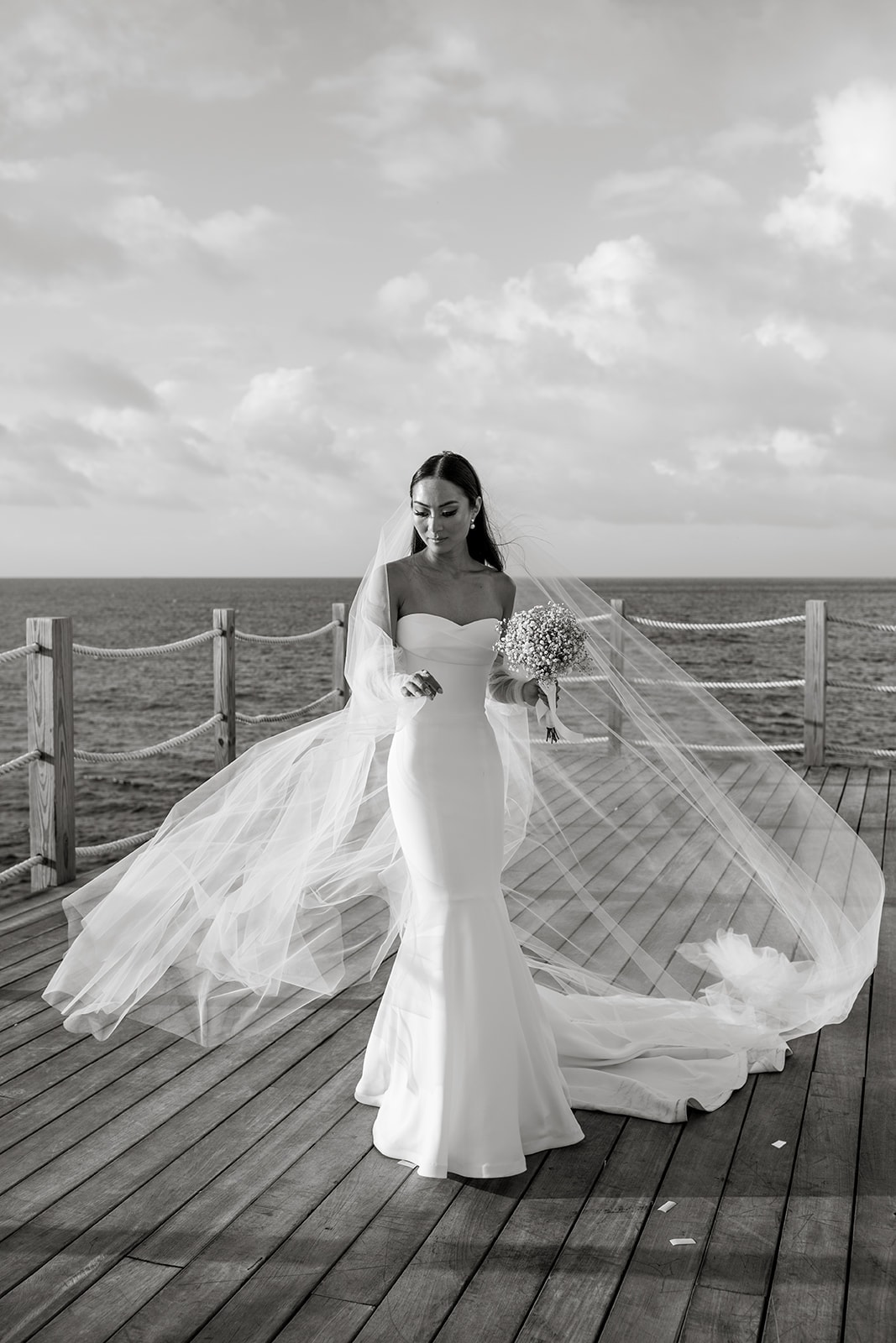 Bride in Anguilla stands for bridal portraits while veil blows in the wind