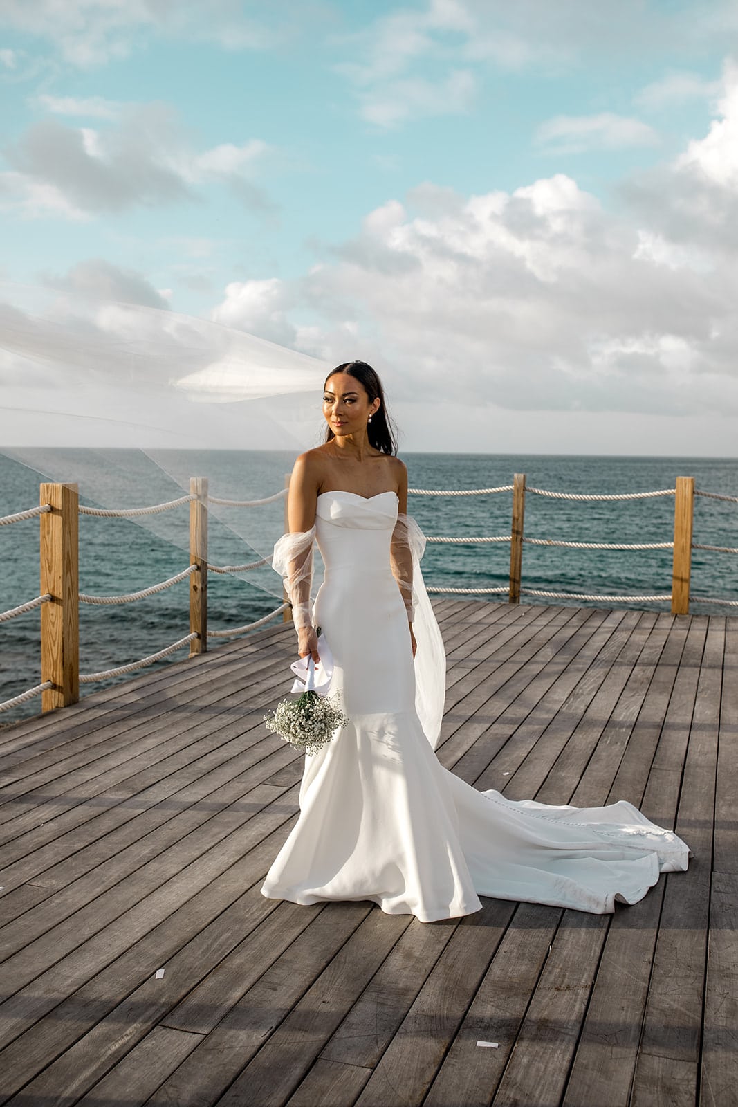 Bride stands on dock in Anguilla during bridal portraits