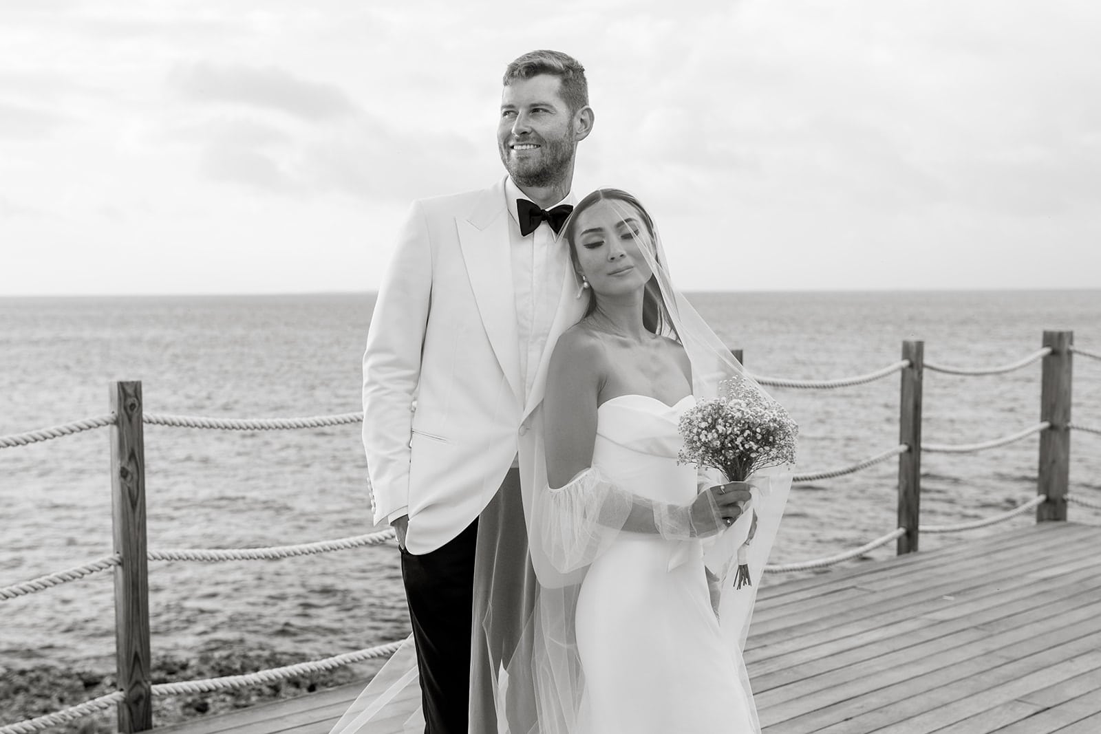 Bride and groom stand together on dock in Anguilla