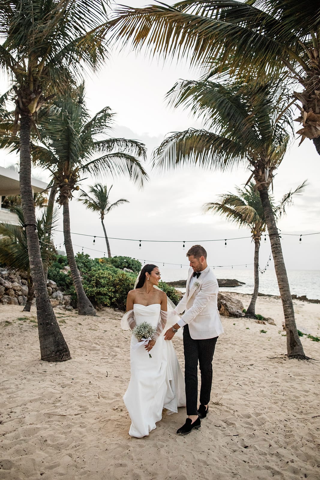 Bride and groom walk on sandy Anguilla beach after wedding