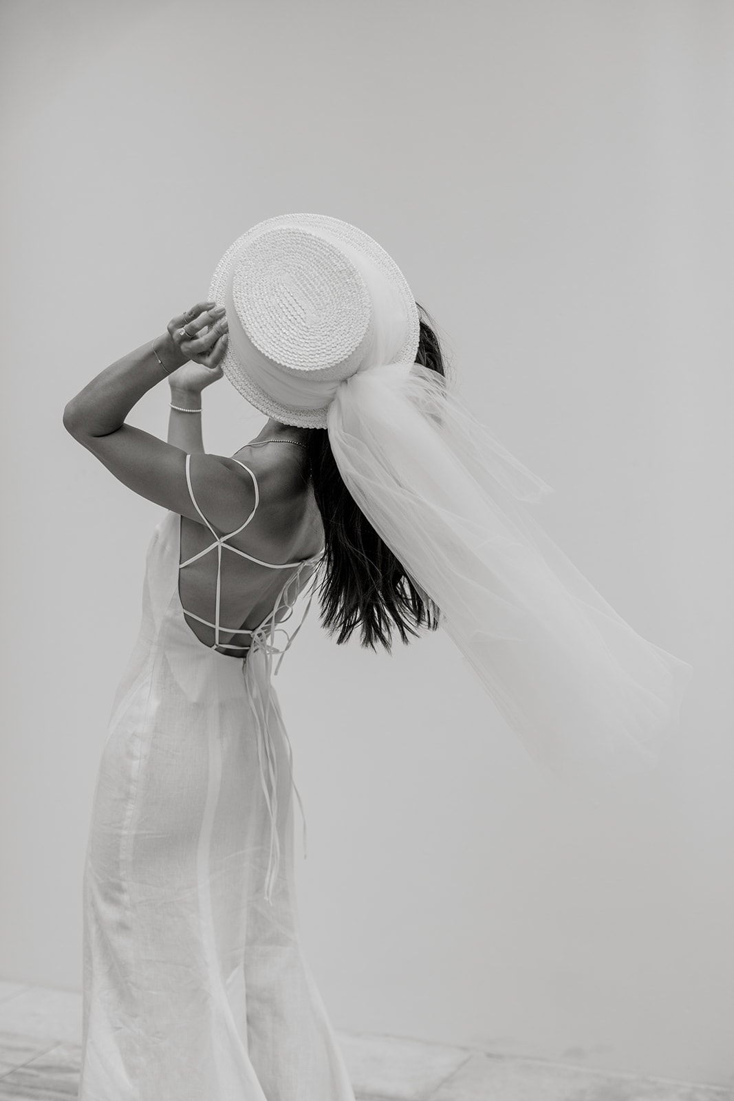 Editorial portrait with bride wearing a hat with a veil