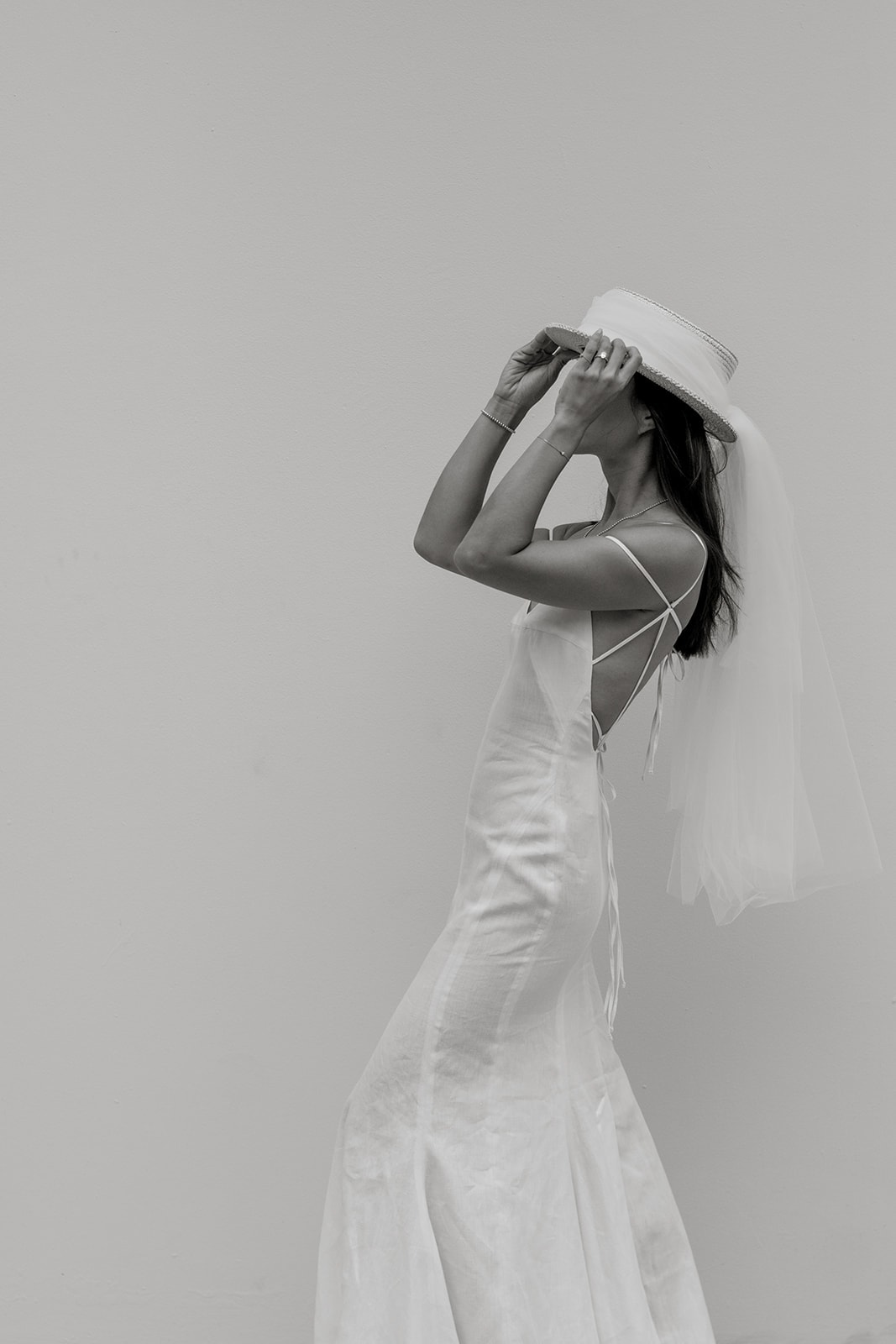 Editorial bridal portrait while bride wears hat and elegant gown