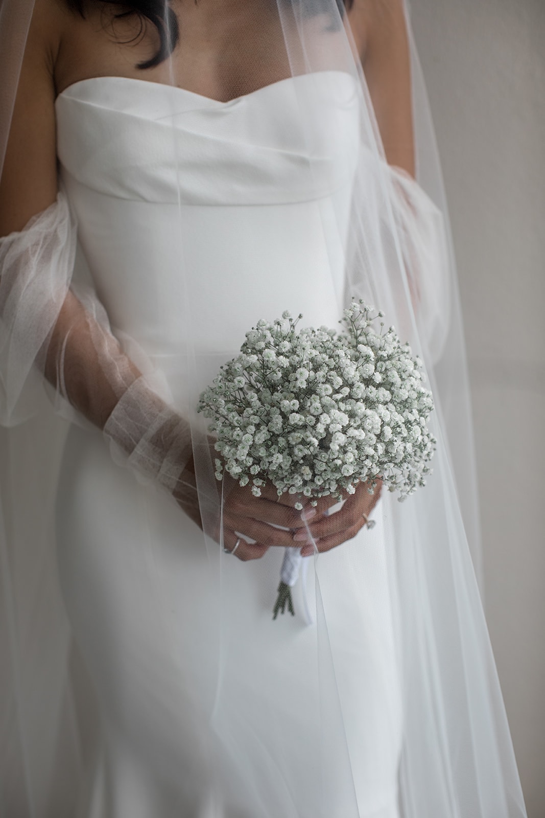 Bride holds simple wedding bouquet of baby's breath
