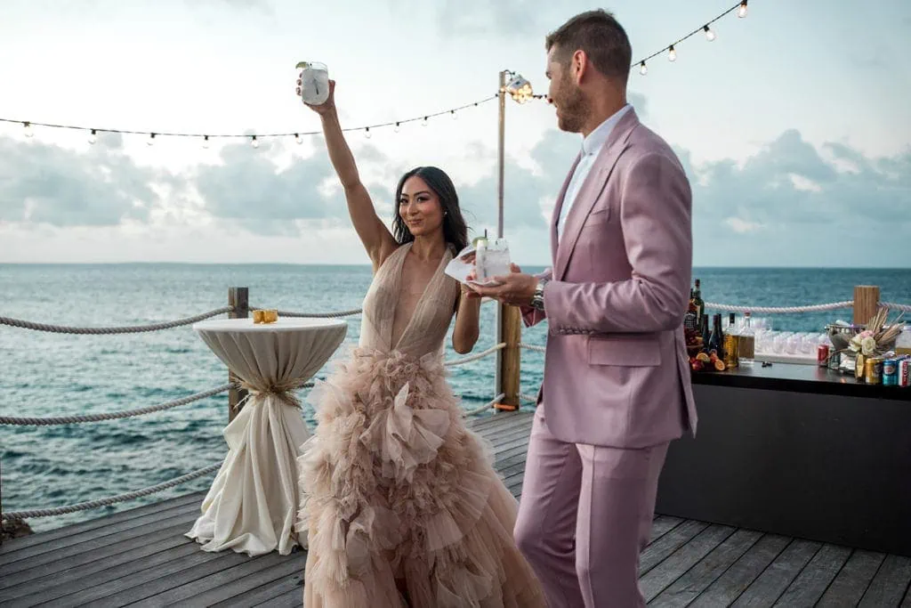 Woman toasts guests at rehearsal dinner for Anguilla destination wedding