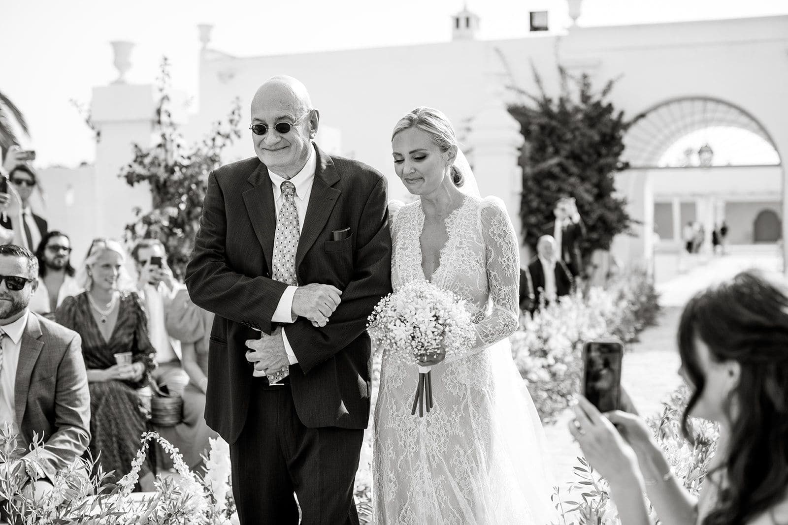 Bride and her father walk down wedding ceremony aisle