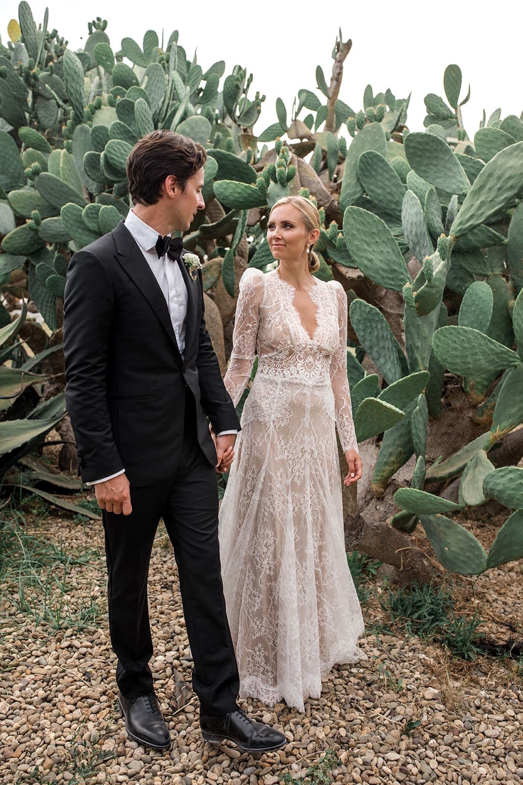 Bride and groom walk near cactus in Puglia Italy after destination wedding