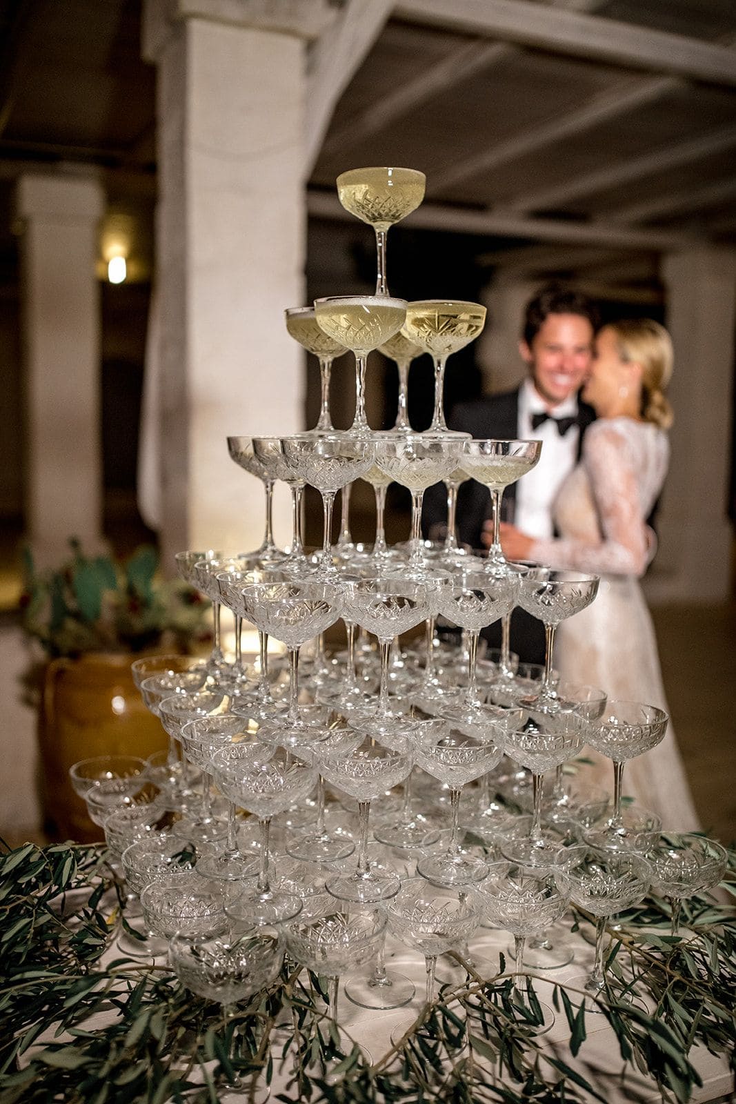 Bride and groom with champagne tower at wedding reception
