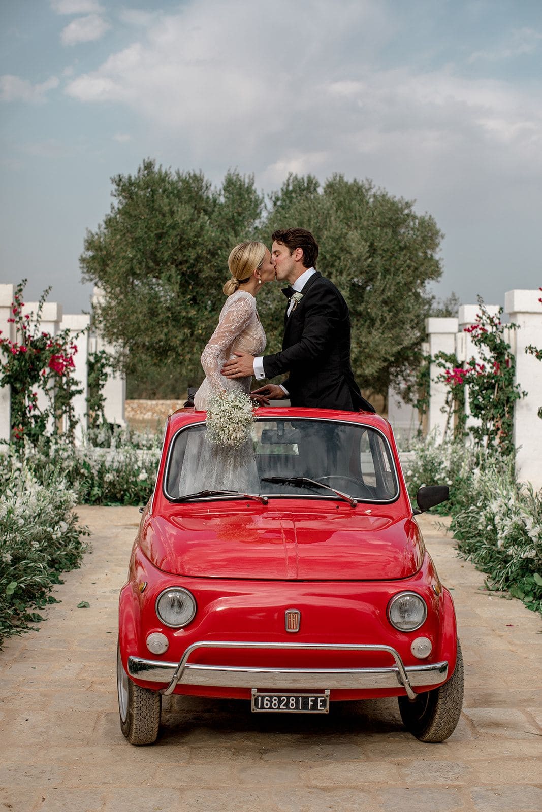 Bride groom kiss inside red car Puglia Italy