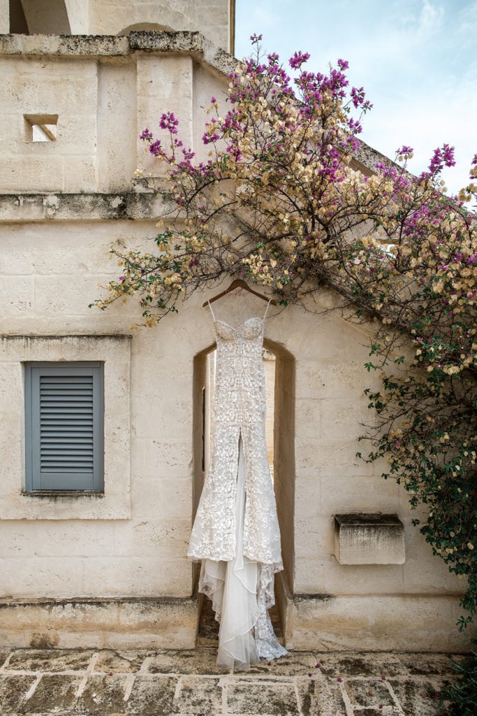 A Galia Lahav bridal grown hangs from the olive branches at a Borgo Egnazia wedding. 