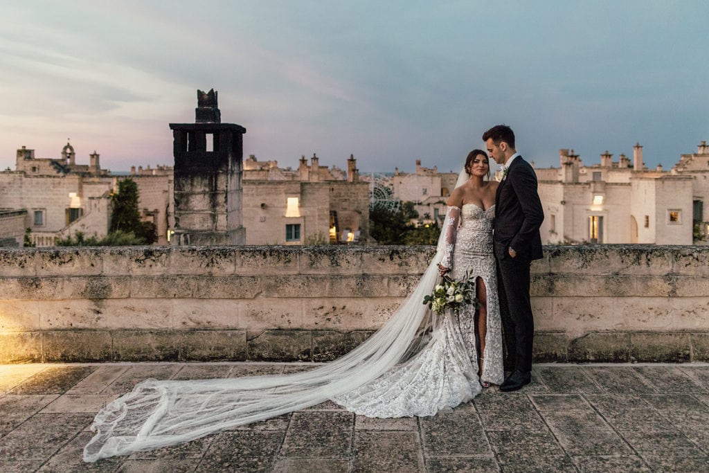 A bride and groom stand together for a bridal portrait on a rooftop in Puglia, Italy. 