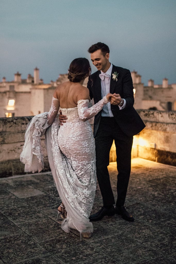 A bride and groom dance together on a rooftop in Puglia, Italy. 