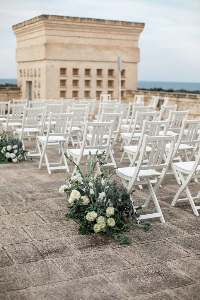 Floral pieces mark each aisle for a Borgo Egnazia wedding ceremony. 