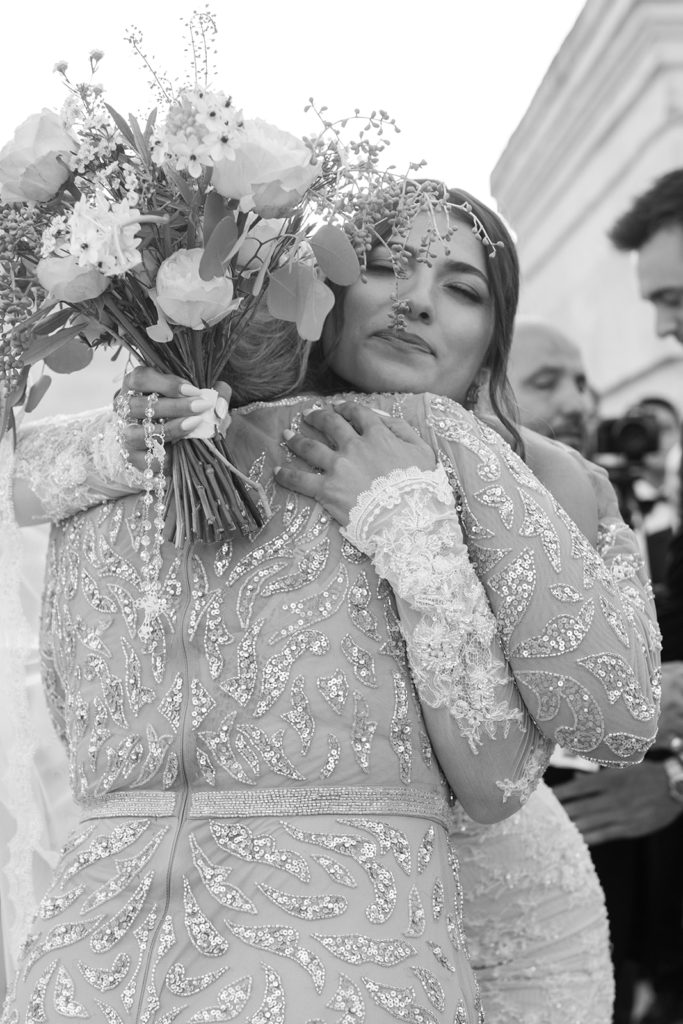 A bride hugs her mother before standing next to her groom at the wedding ceremony. 