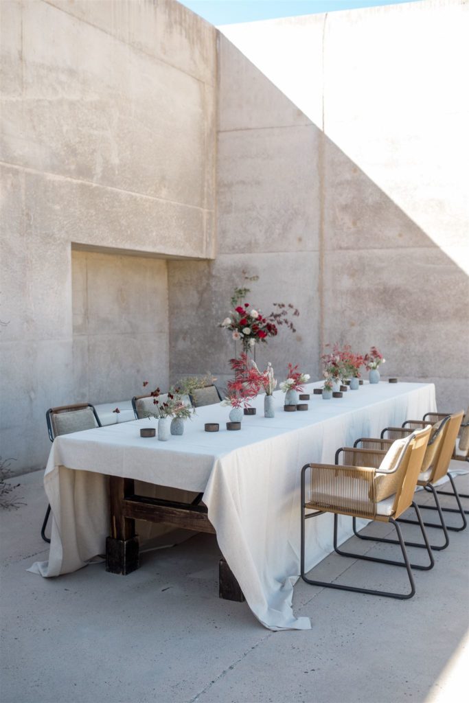 A banquet-style table is set before an intimate luncheon at an Amangiri elopement. 