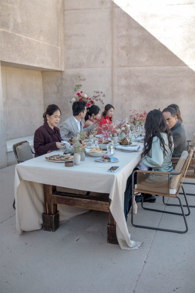 Family of the bride and groom sit and eat lunch together at a private table at Amangiri.