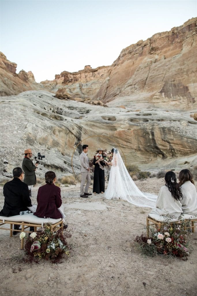 A bride and groom are married by an officiant among family in the Utah canyons and plateaus. 