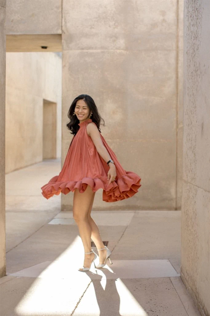 A woman twirls in a red dress at her Amangiri elopement. 