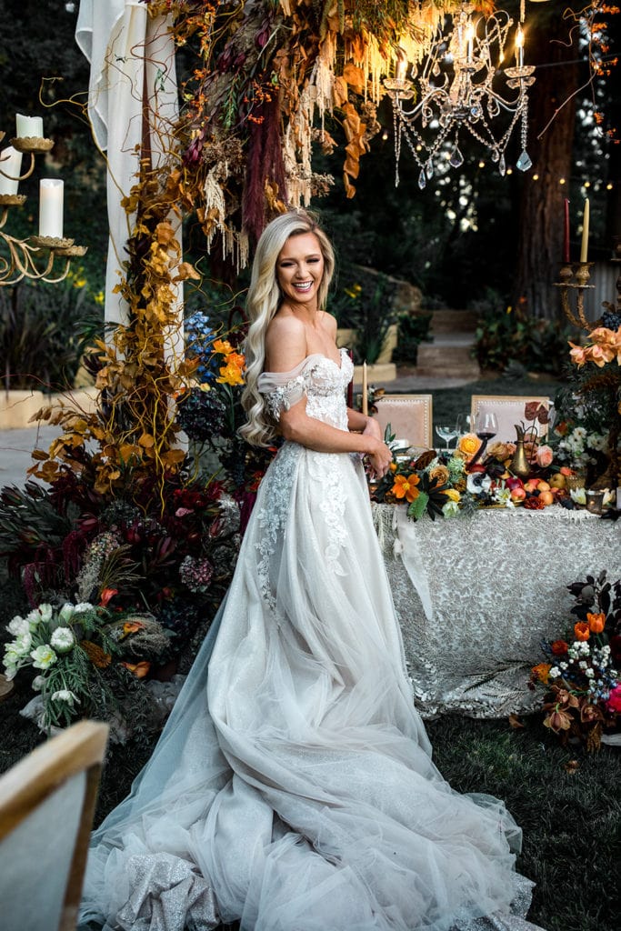 A bride stands in front of her sweetheart table at a wedding reception for a Napa Valley wedding. 