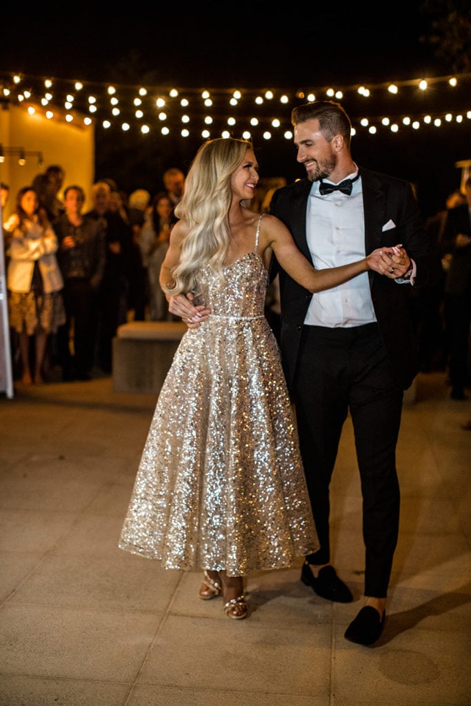 Bride and groom, who wears a modern fitting groom's tuxedo after finding groom's tuxedo ideas, dance at wedding reception
