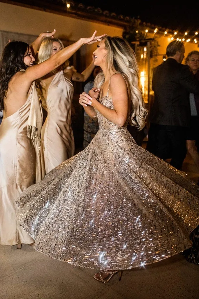 A bride twirls in a sparkly Berta dancing dress at her wedding reception. 