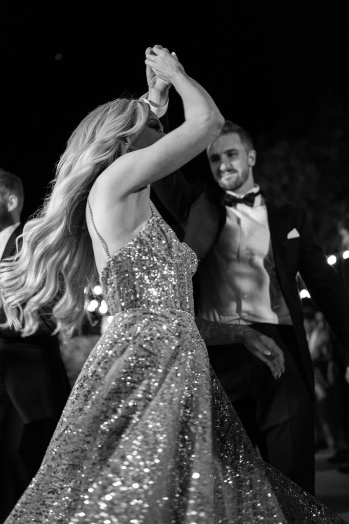 A groom spins her bride in a beautiful dance together. 