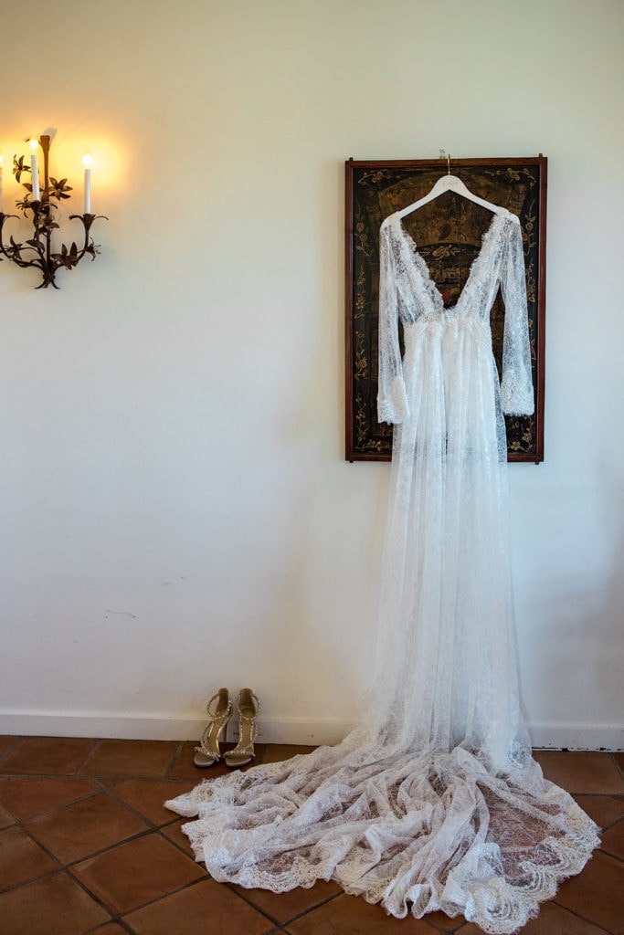 A Le Laurier bridal robe hangs from a classic portrait in the bridal ensuite at  a Calistoga Vineyard Estate wedding.