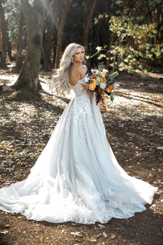 A bride poses for bridal portraits in a stunning Galia Lahav wedding gown with a bright bridal bouquet. 