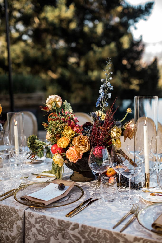 Large, vibrant floral centerpieces line the banquet-style tables at a Calistoga Vineyard Estate wedding reception. 