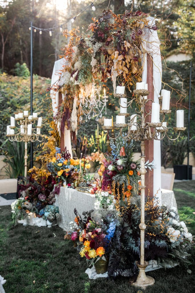 6 foot tall candelabras frame the sweetheart table at a Calistoga Vineyard Estate wedding reception. 