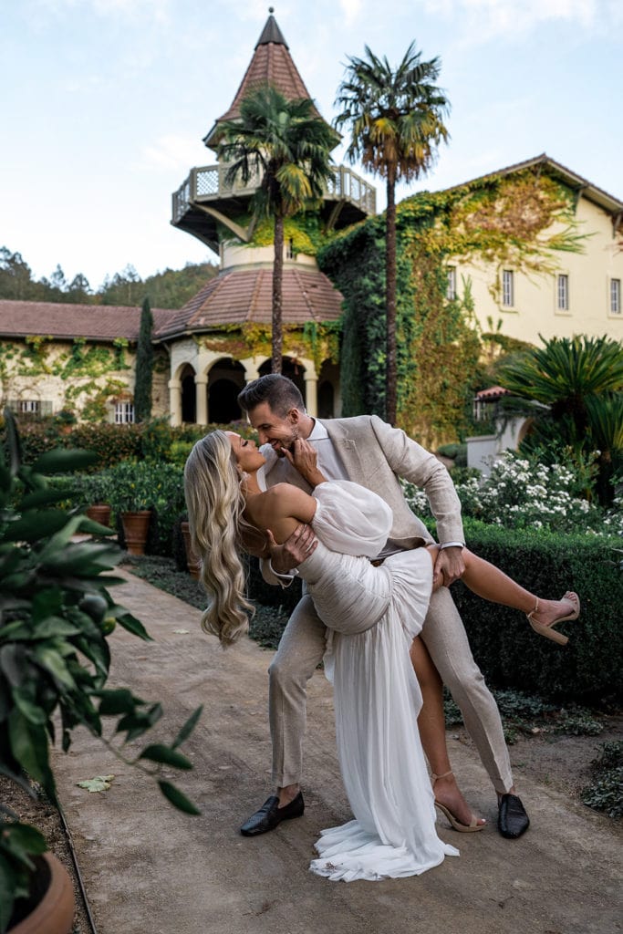 A groom dips his bride and kisses her at their rehearsal dinner before their Napa Valley Wedding. 