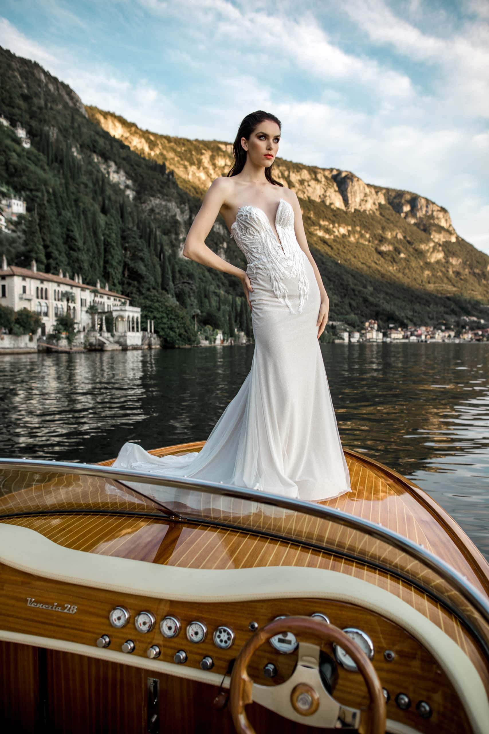 Model poses for bridal gown photography on boat on Lake Como