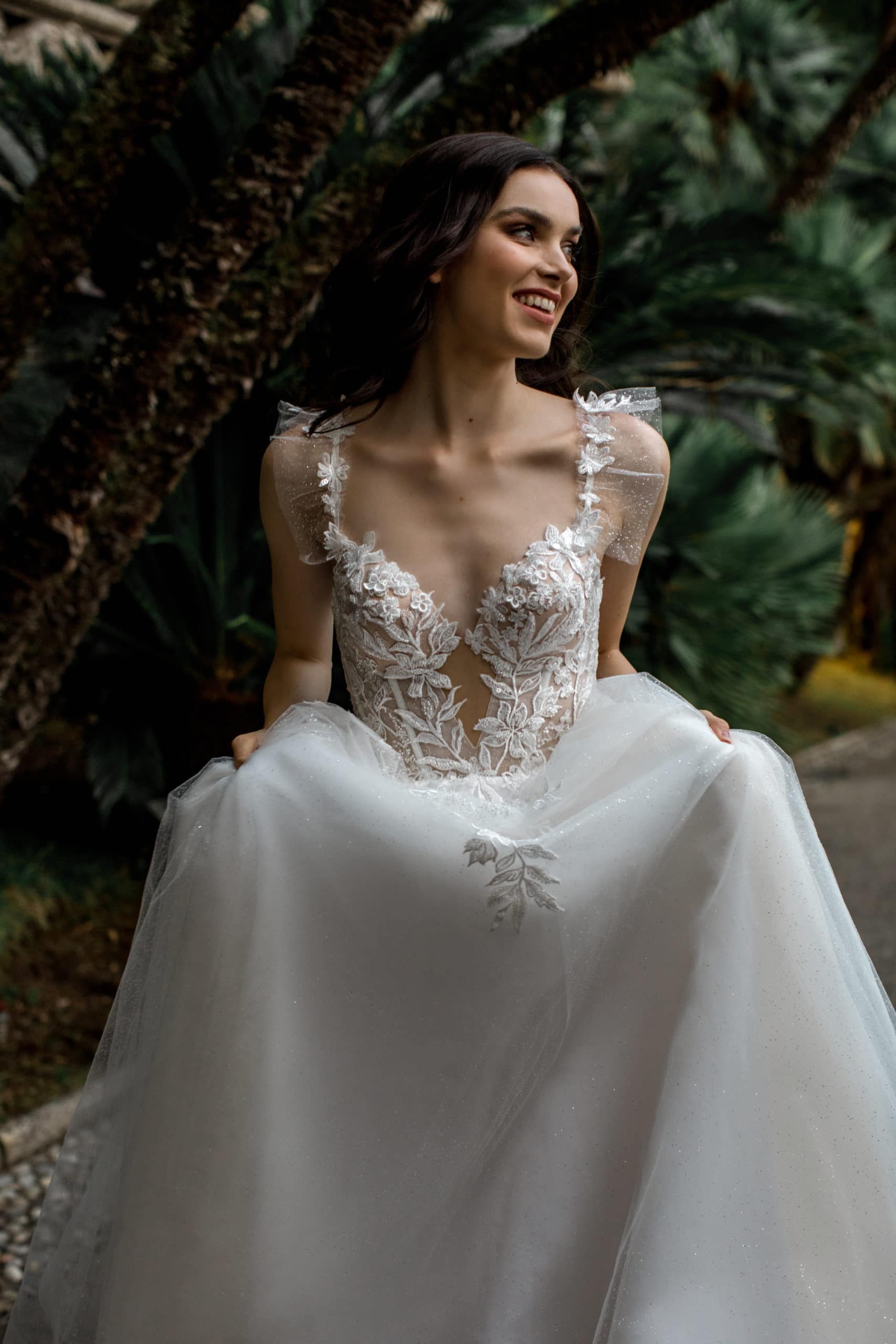 Model holds chiffon skirt up of Ari Villoso bridal gown