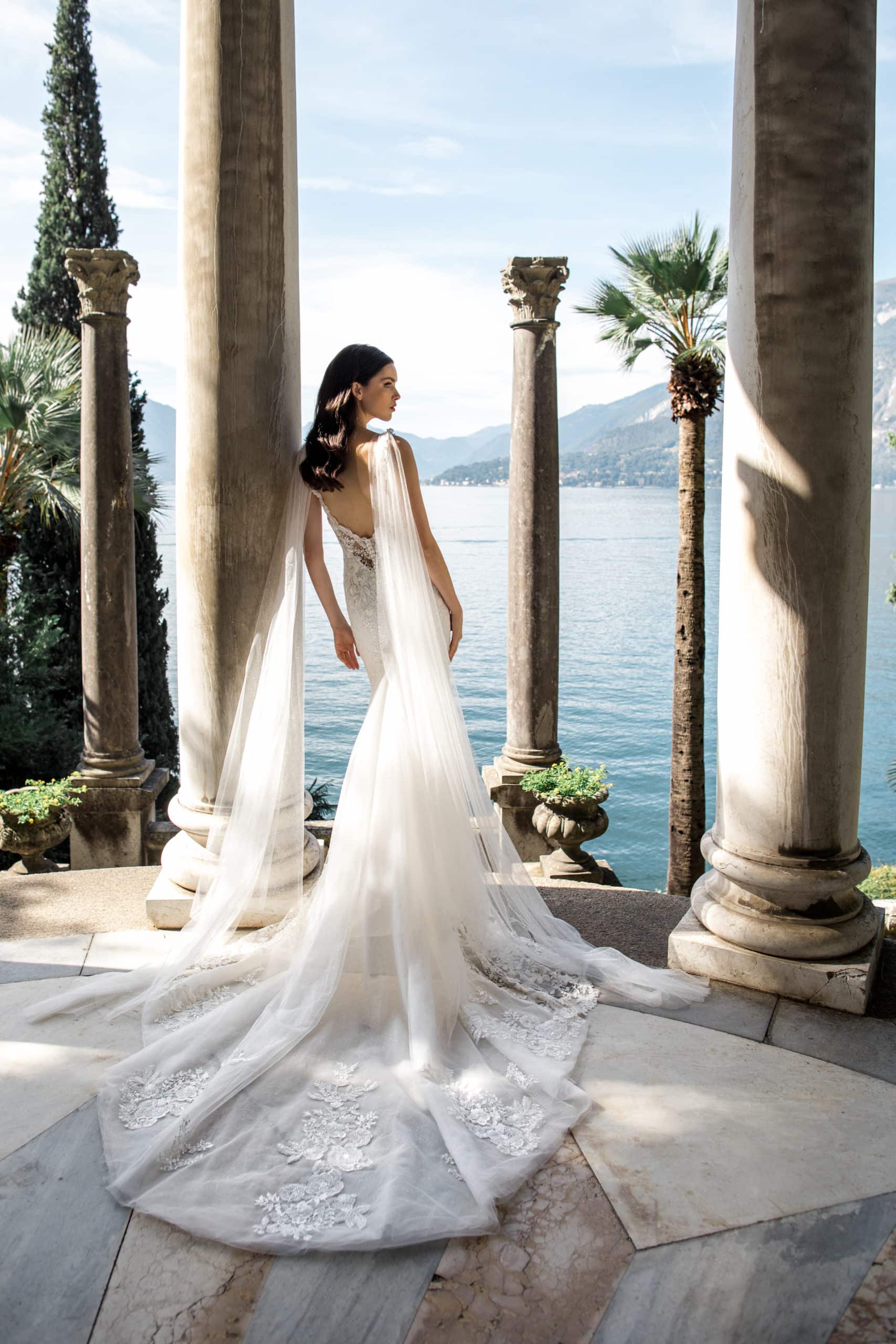 Model wears wedding gown with tulle cape at Villa Monastero