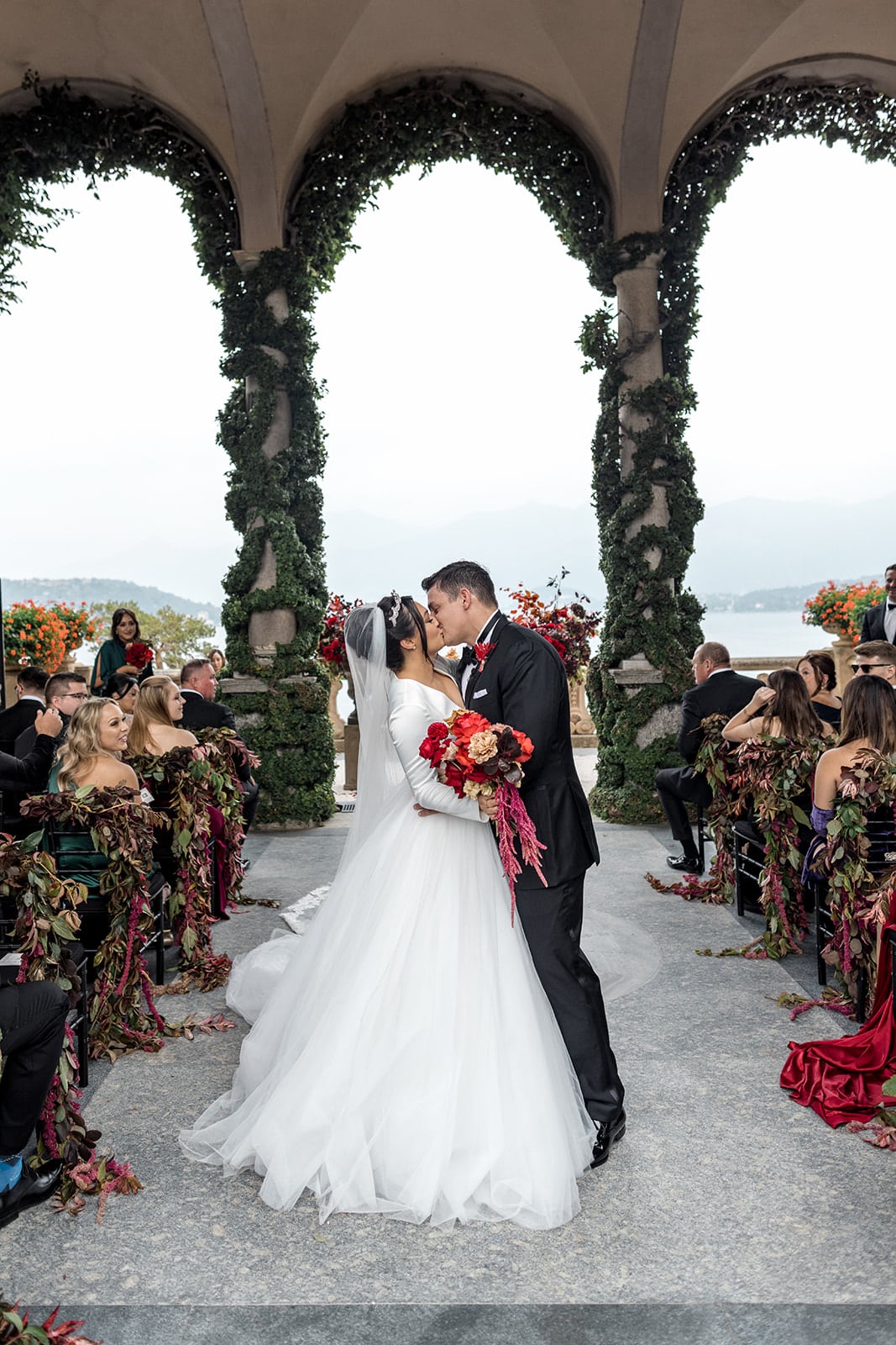Bride and groom kiss ceremony aisle at Villa del Balbianello