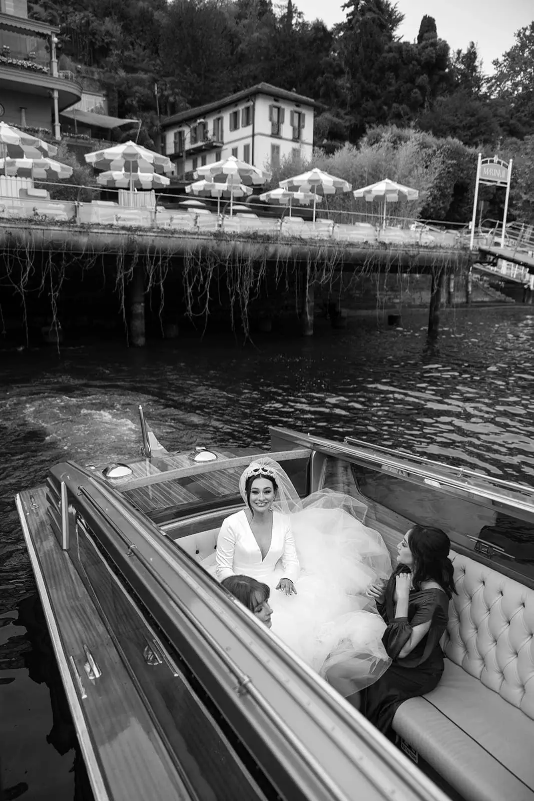 Bride sits in classic Italian boat Lake Como