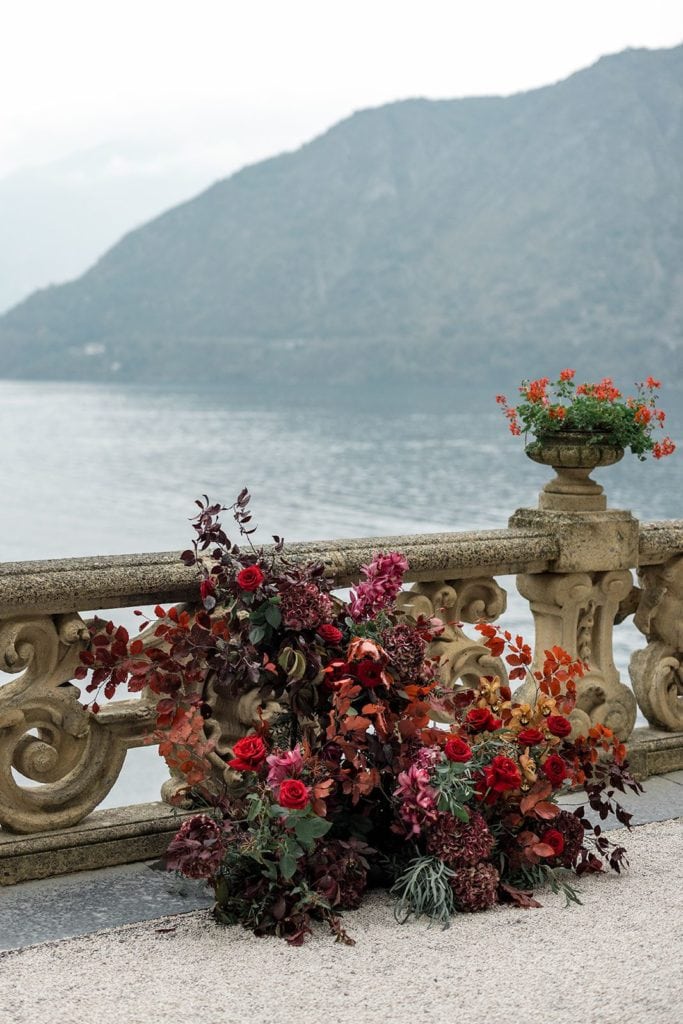 Rich red flower arrangements at wedding ceremony in Lake Como