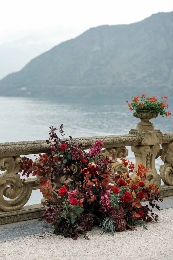 Rich red flower arrangements at wedding ceremony in Lake Como