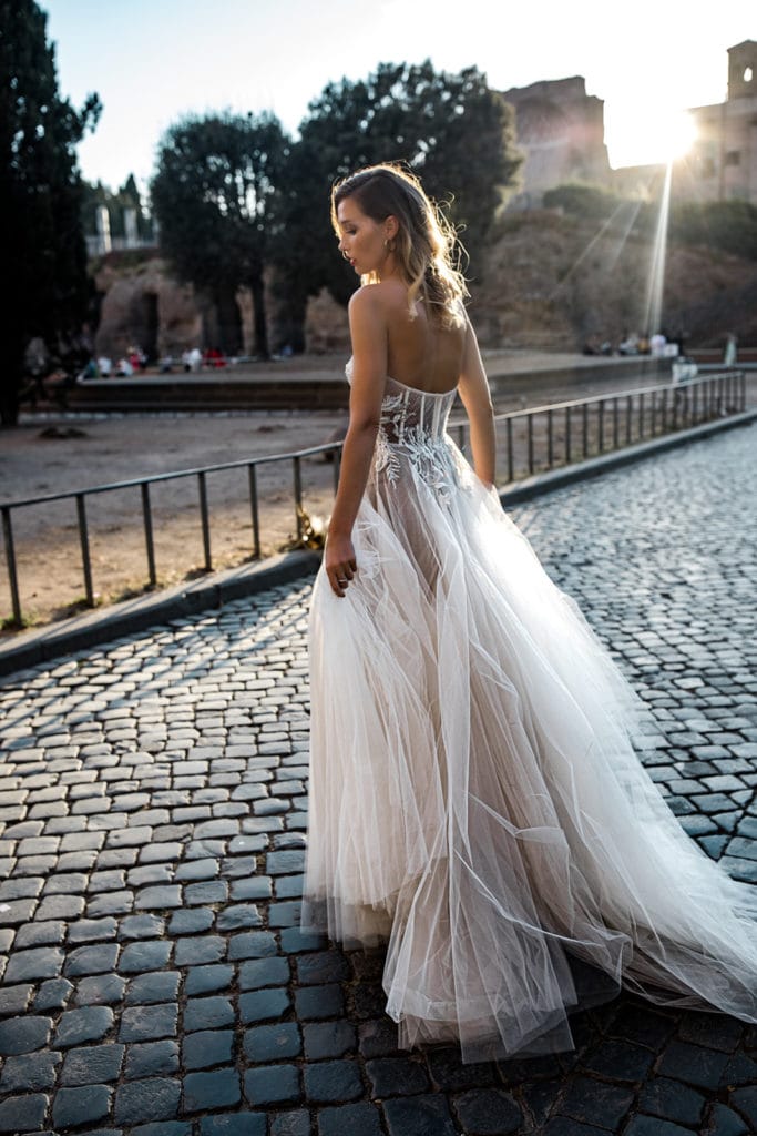 A model bride walks on a cobblestone street in Rome
