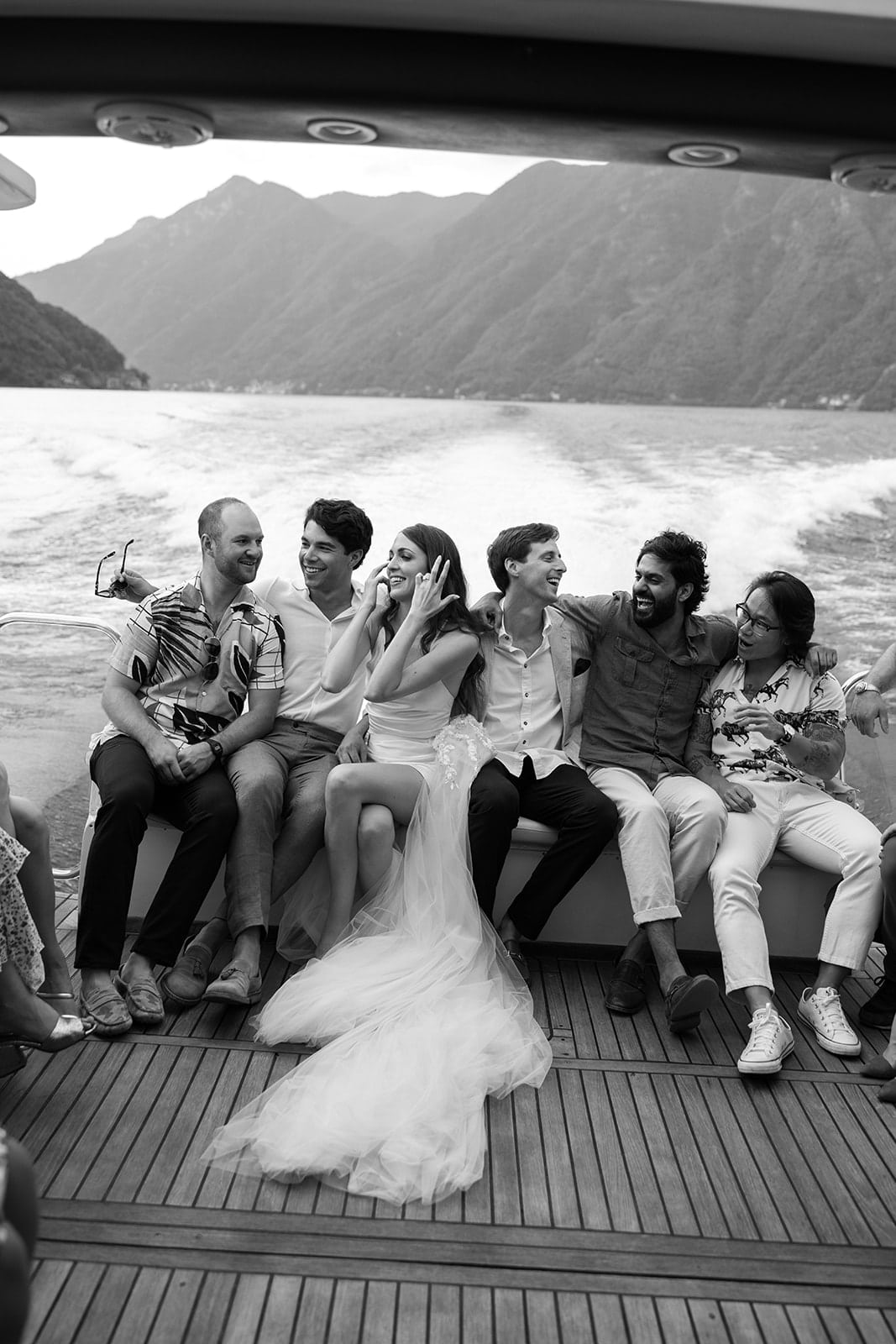 Bridal party sit on a boat on Lake Como