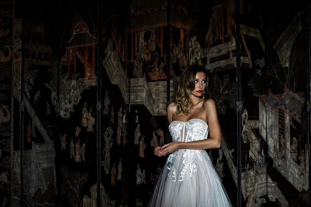 A model bride poses in front of an ornate wall at Villa Clara in Rome