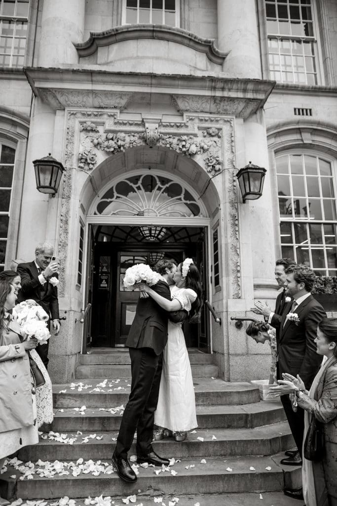 Bride and groom kiss after getting married at London courthouse