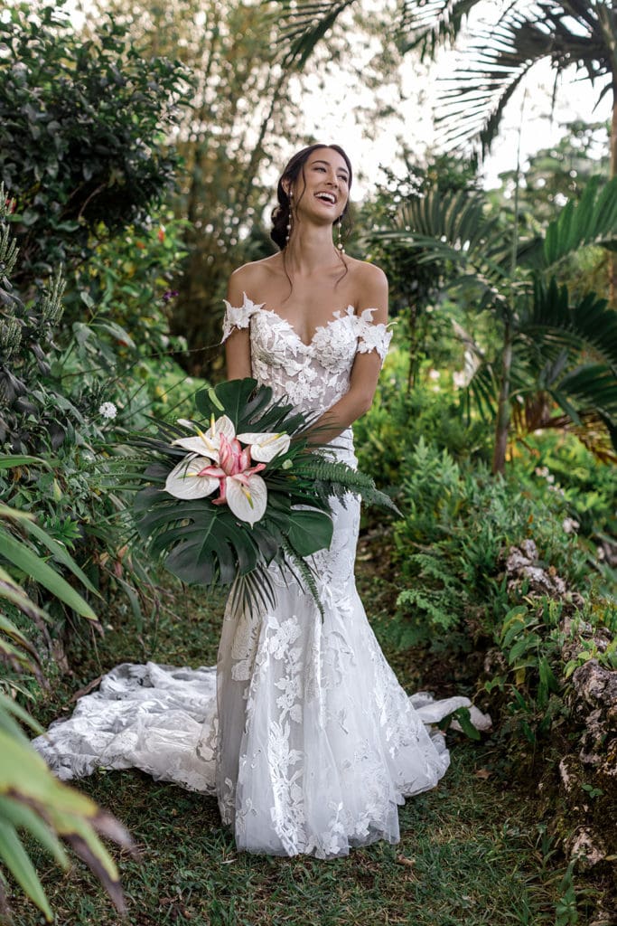 Bride stands with her bridal bouquet in the rainforest in Jamaica