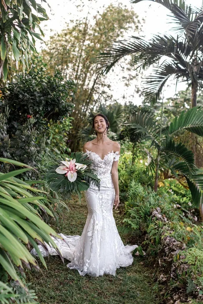 Bride stands among the lush Jamaican rainforest