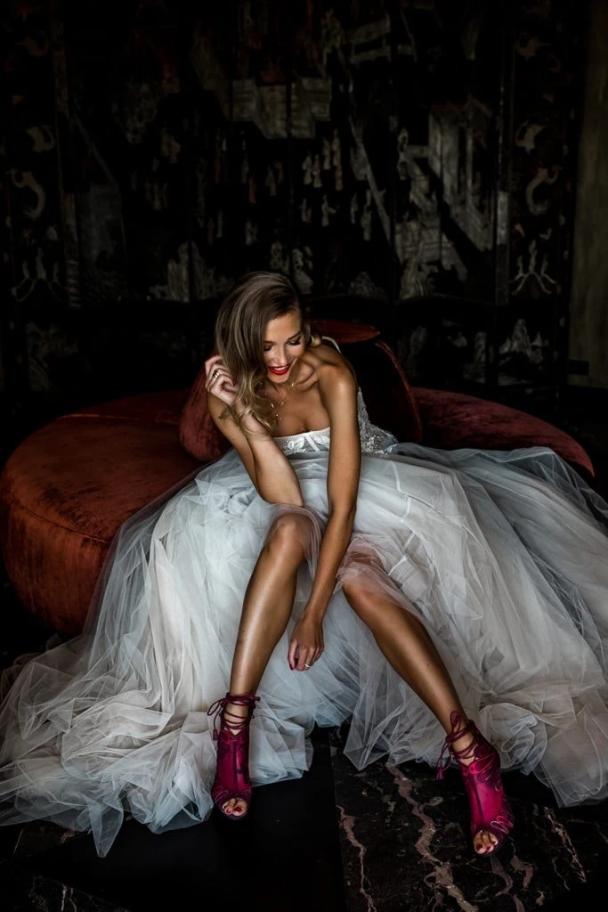 Model bride for a Rome wedding editorial session sits on a plush sofa in a Villa Clara suite 
